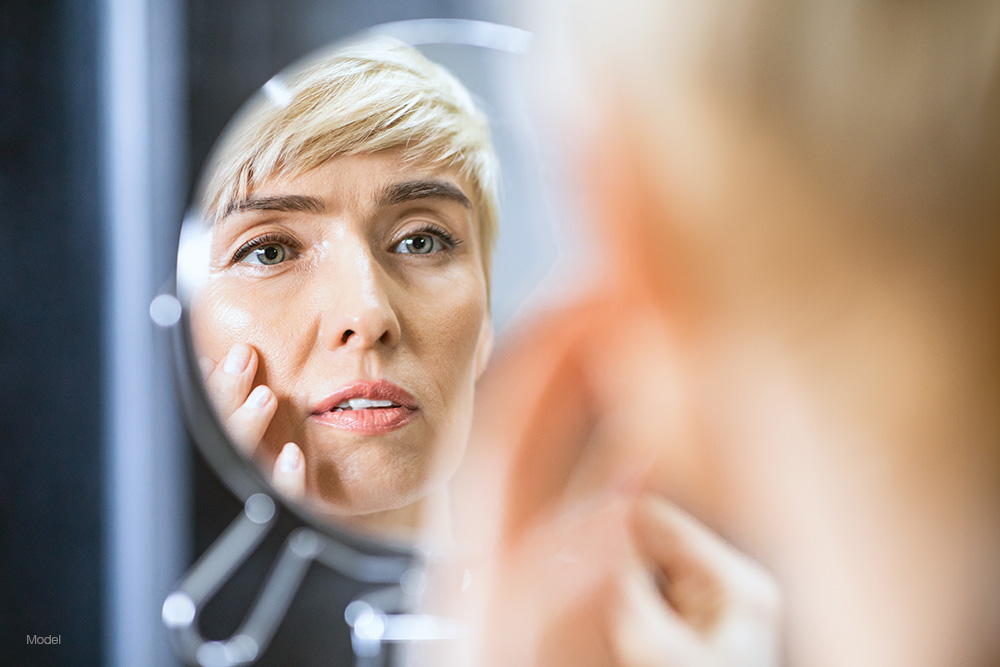 Mature woman looking at herself in the mirror