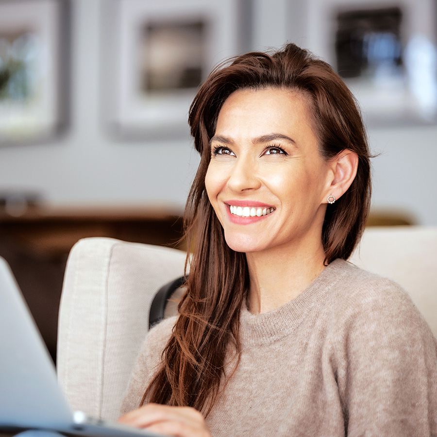 Woman sitting on a couch on a computer